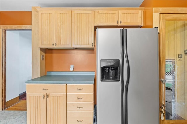 kitchen with stainless steel fridge and light brown cabinetry