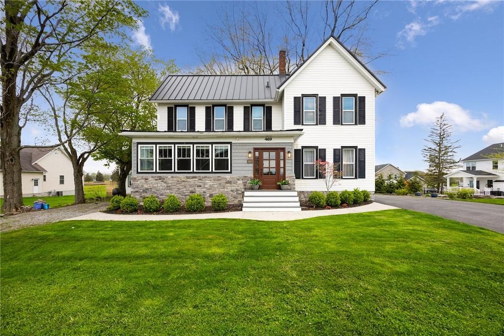 469 Salt Rd, Webster, NY 14580 - modern farmhouse with a front lawn, a chimney, metal roof, stone siding, and a standing seam roof