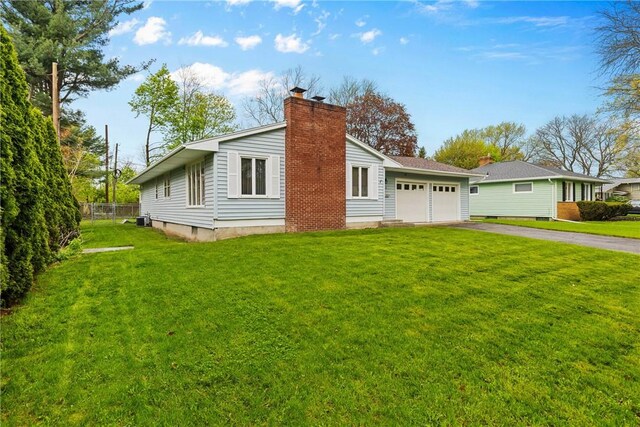 view of side of home with driveway, a garage, and a chimney