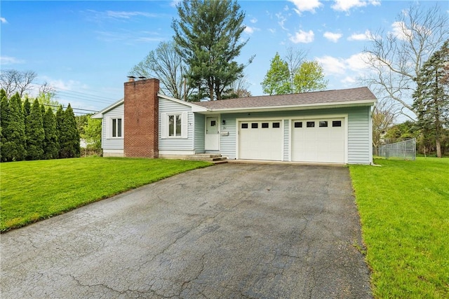 view of front of house with asphalt driveway, a chimney, and an attached garage