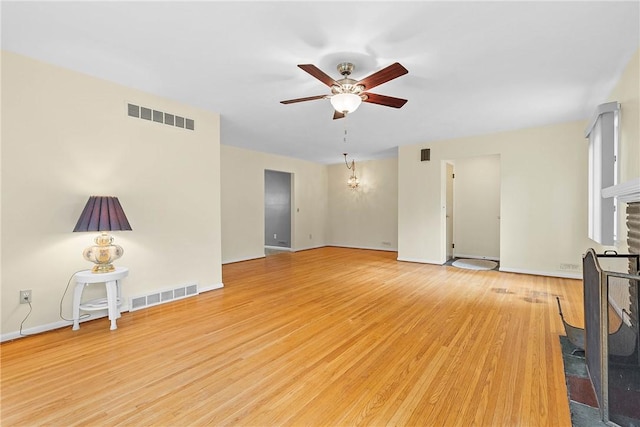 unfurnished living room with a ceiling fan, light wood-style floors, a fireplace, and baseboards