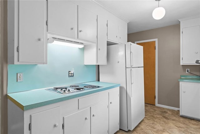 kitchen featuring electric cooktop, freestanding refrigerator, white cabinets, light countertops, and decorative light fixtures