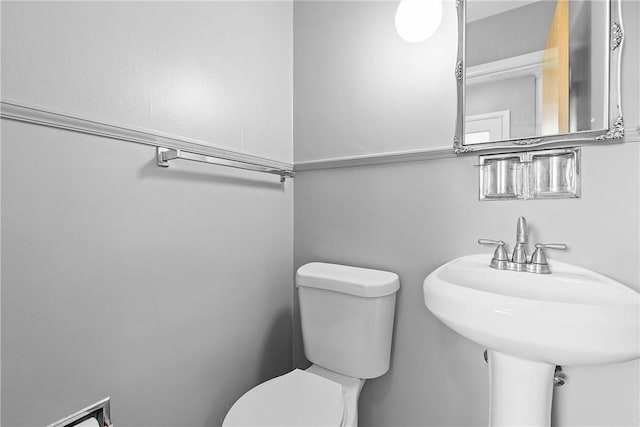 half bath with toilet and a sink