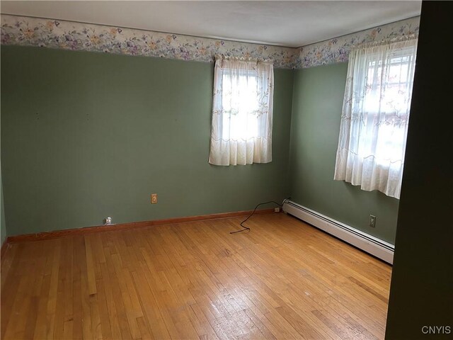 5131 Bear Rd, Clay, NY 13212 - spare room with baseboard heating, hardwood / wood-style floors, and baseboards