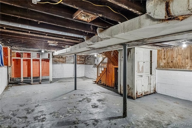 unfinished basement featuring stairs