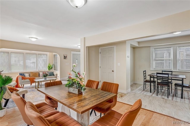 dining room with arched walkways and baseboards