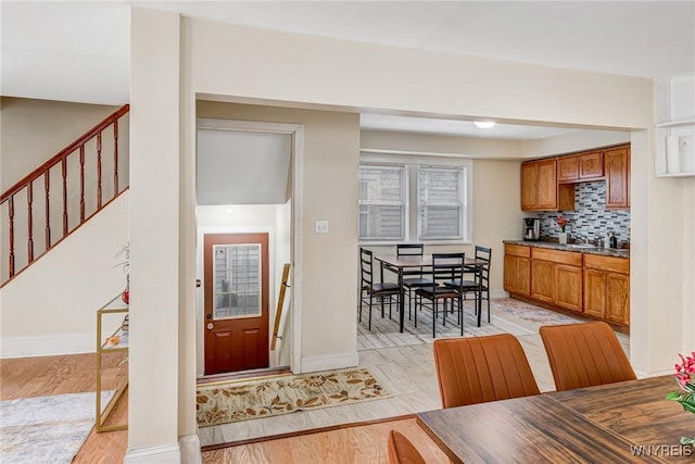 kitchen with backsplash, baseboards, and brown cabinets
