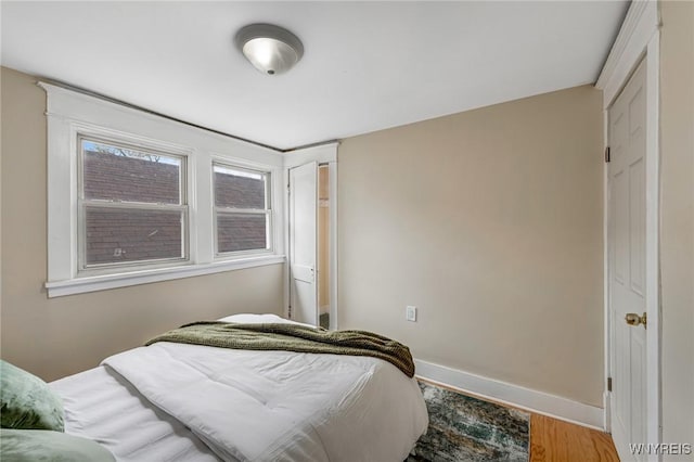 bedroom with baseboards and wood finished floors