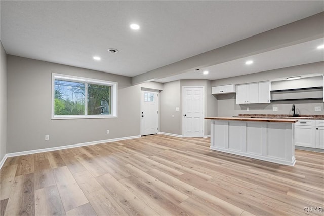 614 E Broadway St, Fulton, NY 13069 - kitchen featuring white cabinetry, baseboards, light wood finished floors, recessed lighting, and a sink