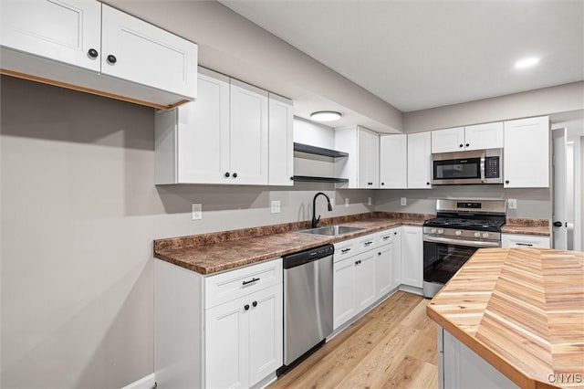 614 E Broadway St, Fulton, NY 13069 - kitchen featuring stainless steel appliances, a sink, butcher block counters, open shelves, and white cabinetry