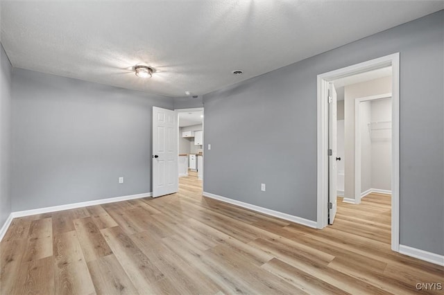 614 E Broadway St, Fulton, NY 13069 - unfurnished bedroom featuring light wood-style flooring, baseboards, and a textured ceiling