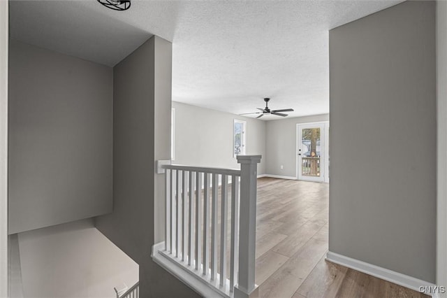 614 E Broadway St, Fulton, NY 13069 - hall with an upstairs landing, baseboards, wood finished floors, and a textured ceiling
