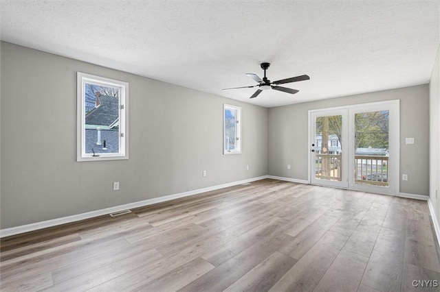 614 E Broadway St, Fulton, NY 13069 - spare room with healthy amount of natural light, wood finished floors, ceiling fan, baseboards, and a textured ceiling