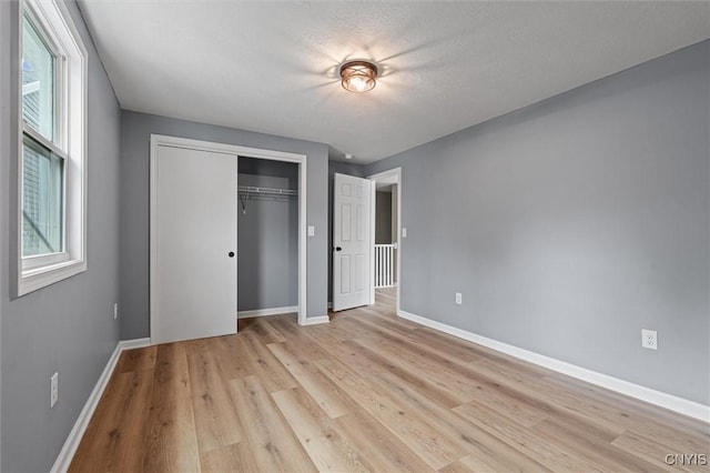 614 E Broadway St, Fulton, NY 13069 - unfurnished bedroom with baseboards, a closet, and light wood-style flooring