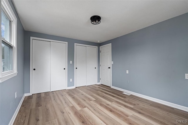 614 E Broadway St, Fulton, NY 13069 - unfurnished bedroom featuring two closets, wood finished floors, and baseboards