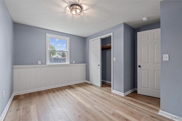 614 E Broadway St, Fulton, NY 13069 - unfurnished bedroom with wood finished floors, a textured ceiling, a closet, and baseboards