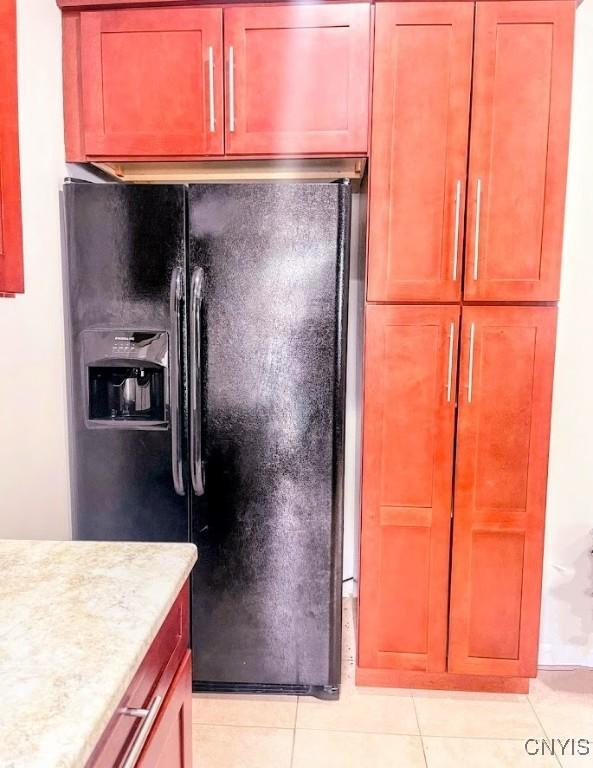kitchen featuring black fridge and light tile patterned floors