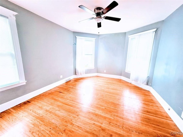 unfurnished room featuring wood finished floors, ceiling fan, and baseboards