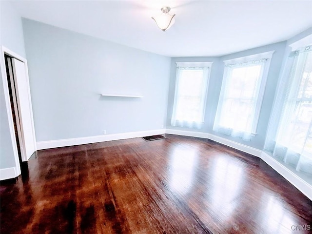 unfurnished room with wood finished floors and baseboards