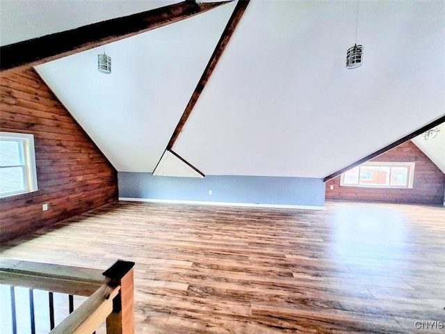 bonus room featuring wood finished floors and wooden walls