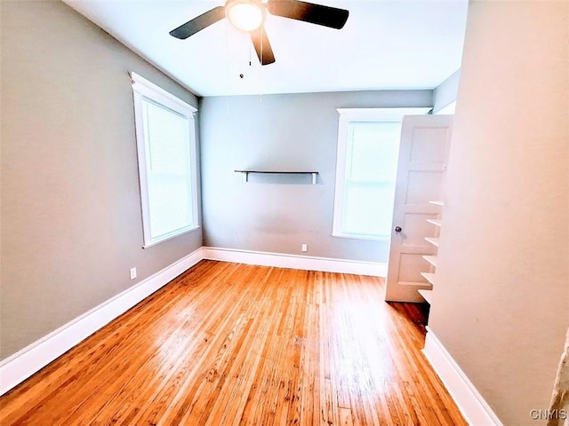 unfurnished bedroom with wood finished floors, baseboards, and a ceiling fan