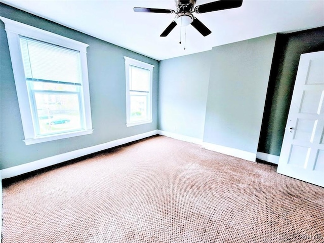 empty room with carpet, ceiling fan, and baseboards