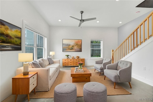 living area featuring healthy amount of natural light, a ceiling fan, stairs, and recessed lighting