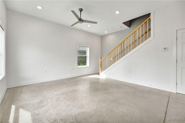 unfurnished living room featuring stairs, a ceiling fan, baseboards, recessed lighting, and finished concrete floors