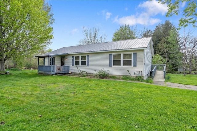 ranch-style house with a front yard, metal roof, and a wooden deck