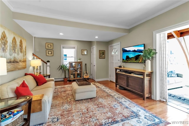 living area with wood finished floors, crown molding, stairs, a baseboard radiator, and recessed lighting