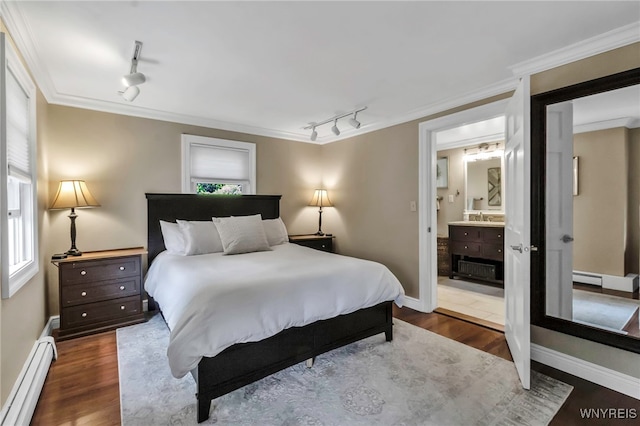 bedroom with track lighting, baseboard heating, a sink, wood finished floors, and ornamental molding