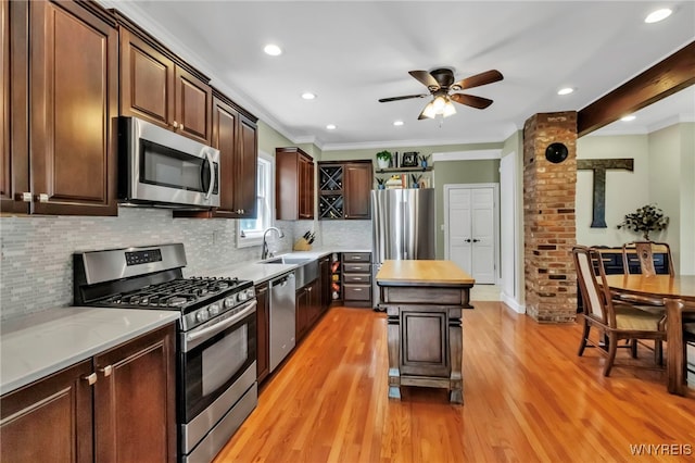 kitchen with appliances with stainless steel finishes, a sink, a ceiling fan, tasteful backsplash, and recessed lighting
