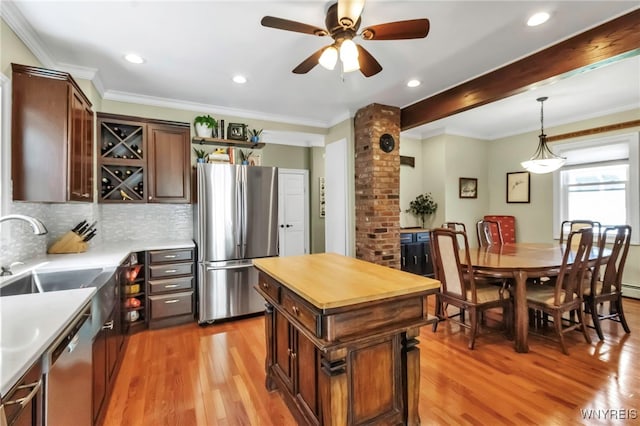 kitchen with stainless steel appliances, a sink, light wood finished floors, decorative backsplash, and recessed lighting