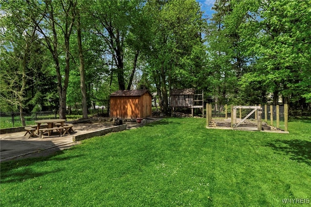 view of yard featuring a storage unit, an outbuilding, a patio area, and view of scattered trees