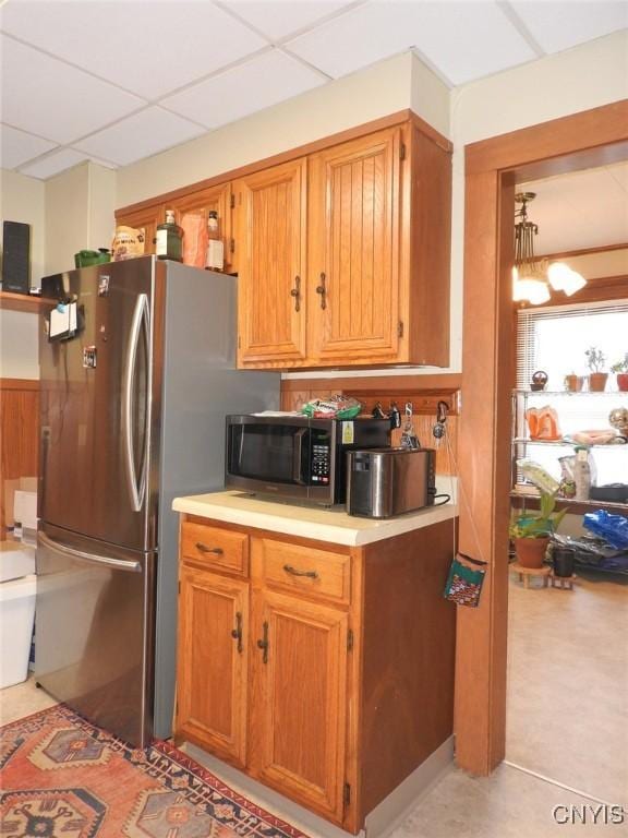 23 Paul St, Auburn, NY 13021 - kitchen with appliances with stainless steel finishes, light countertops, brown cabinets, and a paneled ceiling