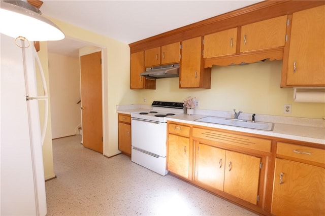 kitchen with white appliances, under cabinet range hood, a sink, and light countertops