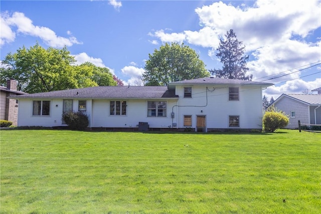 rear view of house featuring a lawn