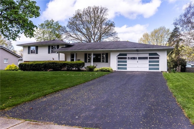 split level home featuring an attached garage, asphalt driveway, and a front lawn