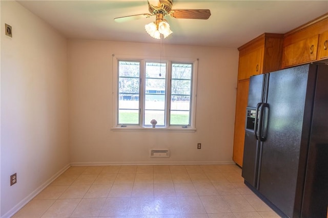 kitchen featuring black fridge, brown cabinets, ceiling fan, and baseboards