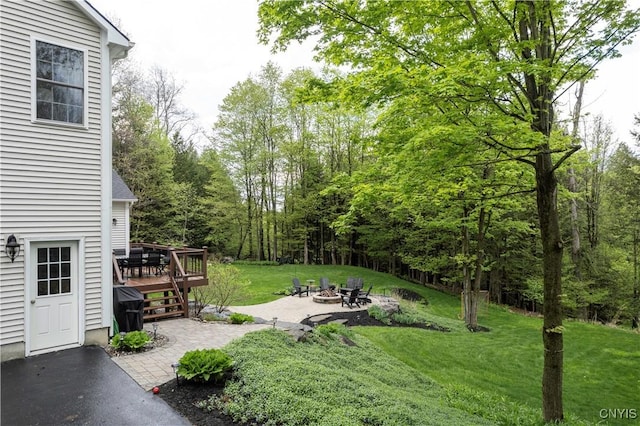 4314 Arbutus Dr, Pompey, NY 13104 - view of green lawn with a fire pit, a wooden deck, and a patio