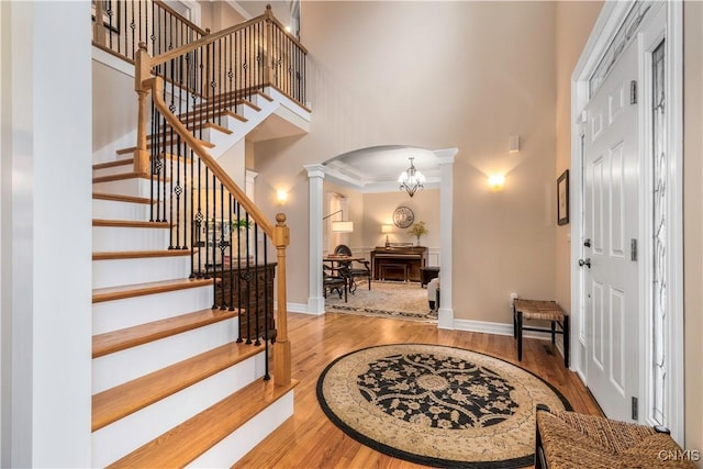 4314 Arbutus Dr, Pompey, NY 13104 - entryway with ornate columns, a high ceiling, wood finished floors, arched walkways, and baseboards