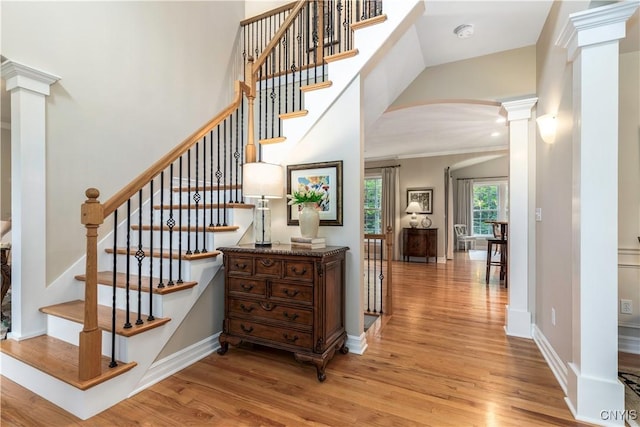 4314 Arbutus Dr, Pompey, NY 13104 - stairway with decorative columns, arched walkways, wood finished floors, baseboards, and a towering ceiling