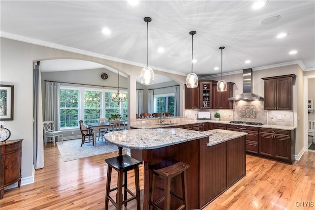 4314 Arbutus Dr, Pompey, NY 13104 - kitchen featuring wall chimney range hood, glass insert cabinets, light wood finished floors, dark brown cabinets, and a sink