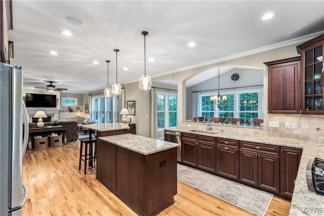 4314 Arbutus Dr, Pompey, NY 13104 - kitchen featuring stainless steel appliances, arched walkways, open floor plan, crown molding, and light wood-style flooring