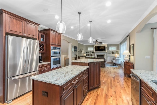 4314 Arbutus Dr, Pompey, NY 13104 - kitchen with appliances with stainless steel finishes, a kitchen island, a fireplace, crown molding, and a ceiling fan