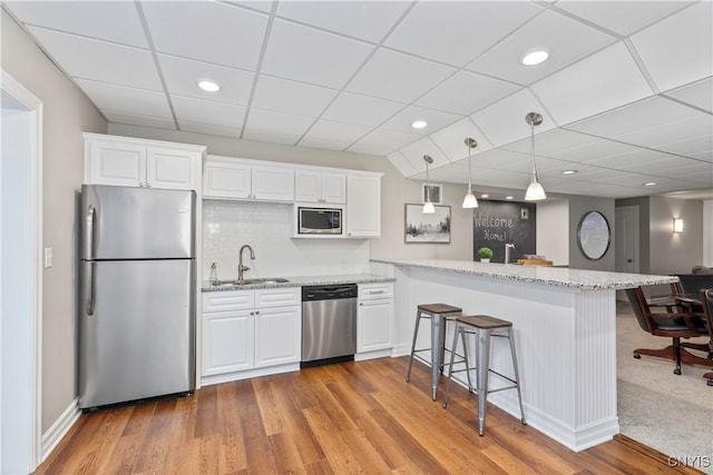 4314 Arbutus Dr, Pompey, NY 13104 - kitchen with stainless steel appliances, a sink, a breakfast bar, wood finished floors, and recessed lighting