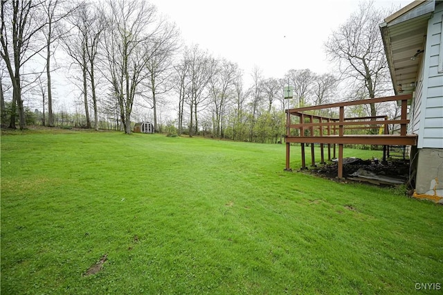 view of green lawn featuring a deck