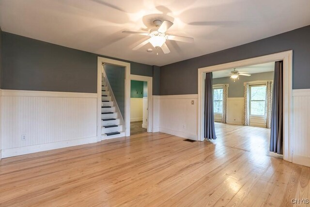 1957 Torpy Pond Rd, Georgetown, NY 13061 - spare room featuring a wainscoted wall, a ceiling fan, light wood-style floors, and stairway