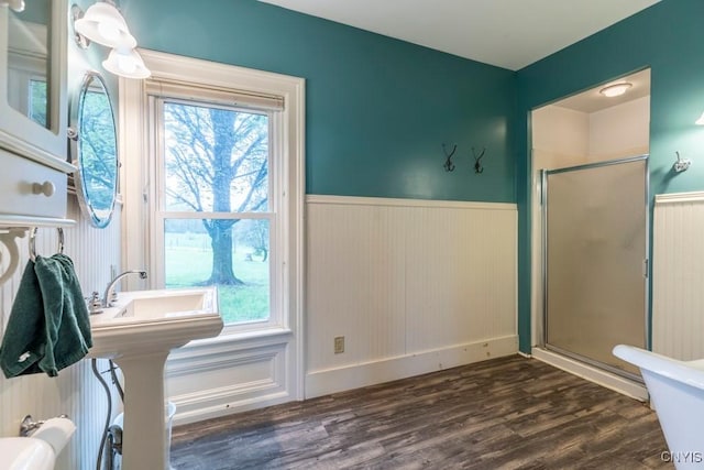 1957 Torpy Pond Rd, Georgetown, NY 13061 - bathroom featuring wainscoting, a stall shower, wood finished floors, healthy amount of natural light, and baseboards