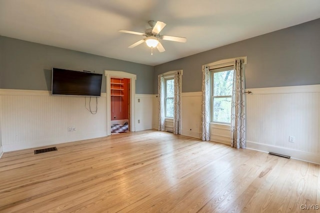 1957 Torpy Pond Rd, Georgetown, NY 13061 - empty room featuring wainscoting, ceiling fan, light wood-style flooring, and baseboards